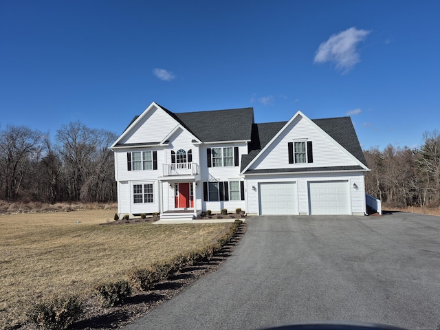 view of front facade featuring a garage, a front lawn, roof with shingles, and driveway