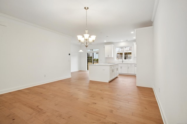 kitchen with ornamental molding, white cabinets, light wood finished floors, and tasteful backsplash