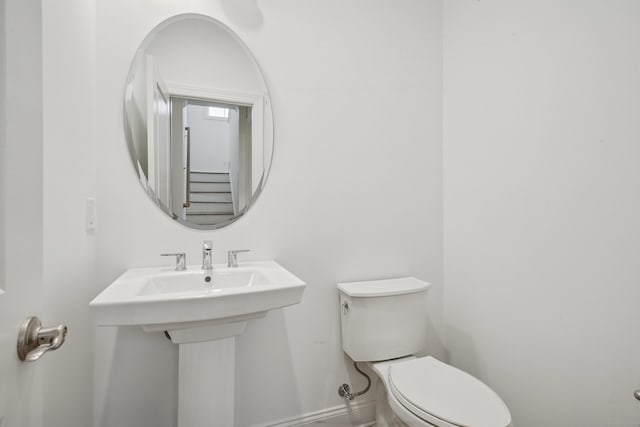 bathroom featuring a sink, toilet, and baseboards