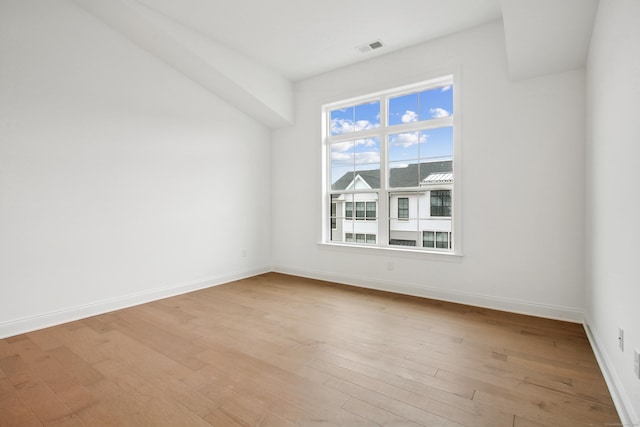 unfurnished room featuring baseboards, visible vents, and light wood-style floors