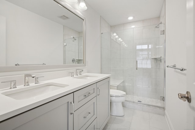 bathroom with a stall shower, a sink, toilet, and double vanity