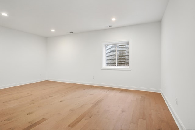 spare room featuring light wood-style flooring, visible vents, baseboards, and recessed lighting