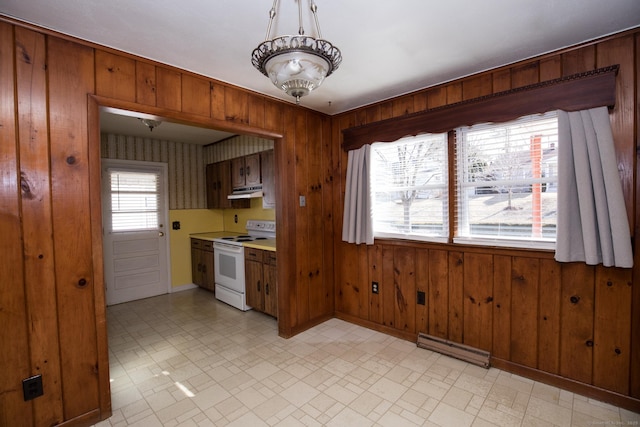 kitchen featuring brown cabinetry, under cabinet range hood, light countertops, white range with electric stovetop, and a baseboard radiator