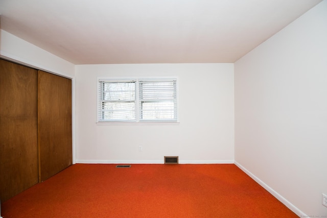 unfurnished bedroom featuring a closet, visible vents, baseboards, and carpet