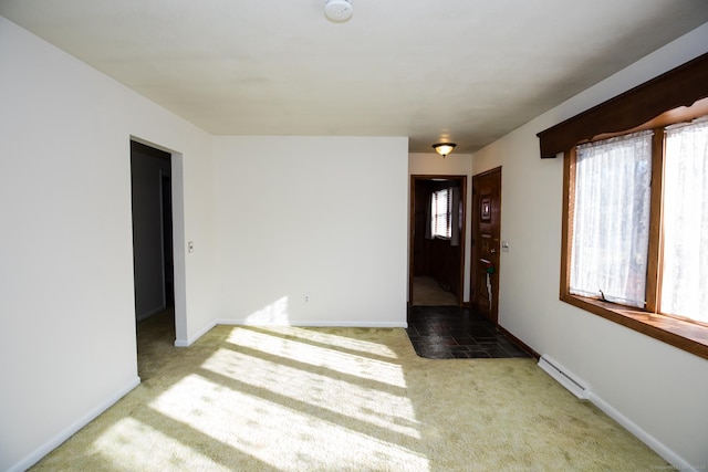 carpeted spare room with baseboards and baseboard heating