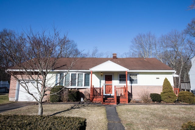 ranch-style house with a front lawn, aphalt driveway, an attached garage, brick siding, and a chimney