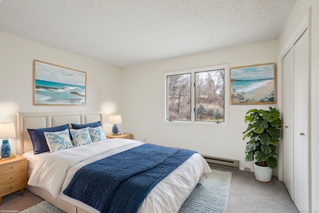 bedroom with a textured ceiling, a closet, a baseboard radiator, and light colored carpet