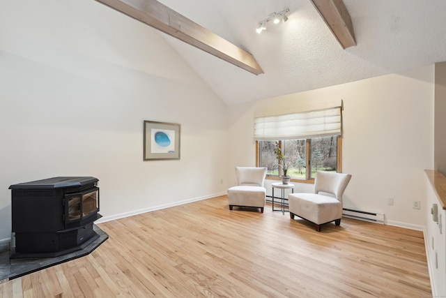 sitting room featuring baseboard heating, wood finished floors, and beam ceiling