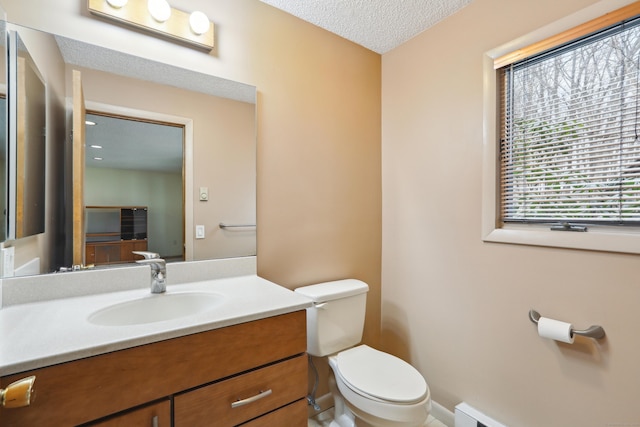 bathroom featuring baseboards, toilet, a textured ceiling, vanity, and a baseboard heating unit