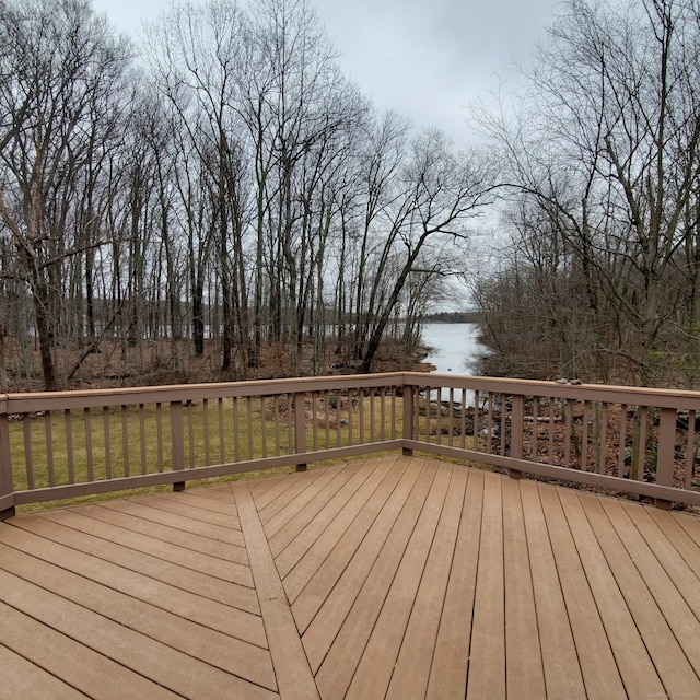 deck with a water view and a lawn