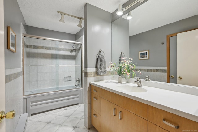 bathroom featuring a textured ceiling, tile patterned flooring, vanity, and tile walls