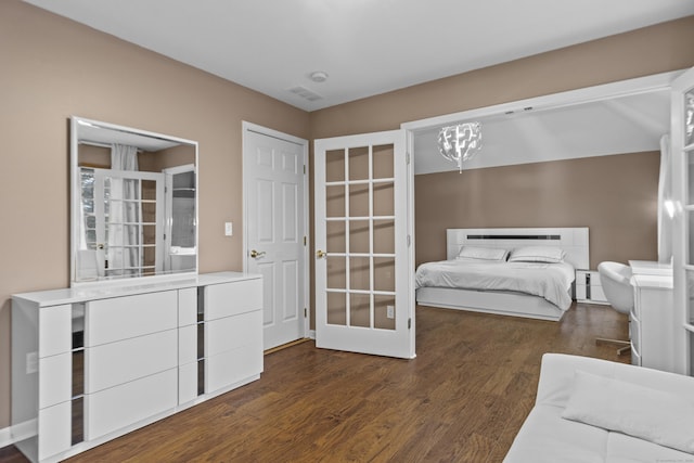 bedroom with a chandelier, visible vents, and wood finished floors