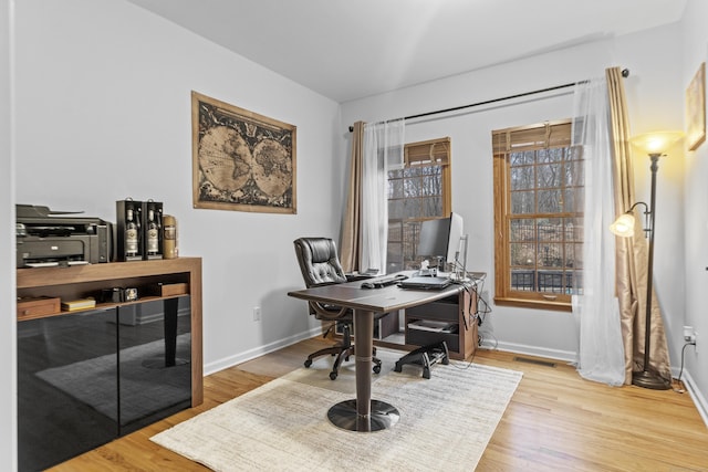 office area featuring visible vents, baseboards, and wood finished floors