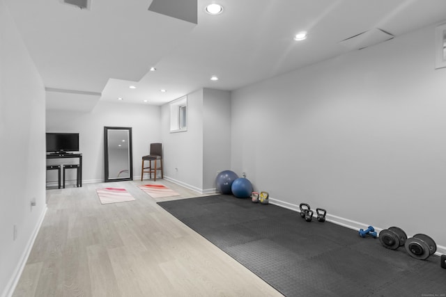 exercise area with baseboards, wood finished floors, and recessed lighting