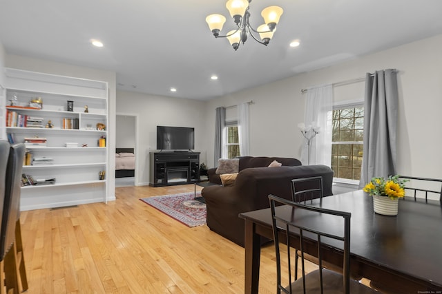 living room with a chandelier, recessed lighting, and light wood-style flooring