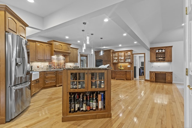 kitchen with glass insert cabinets, stone counters, stainless steel fridge, and light wood finished floors