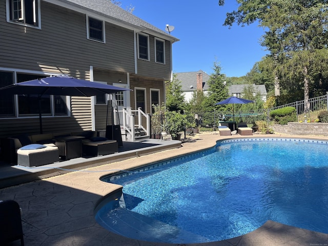 view of pool featuring fence, outdoor lounge area, a fenced in pool, and a patio