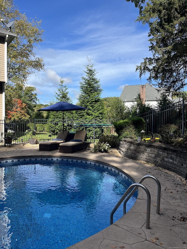 view of swimming pool featuring a fenced in pool, a patio area, and fence