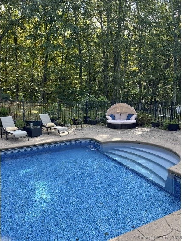 view of pool with a fenced in pool, fence, and a patio