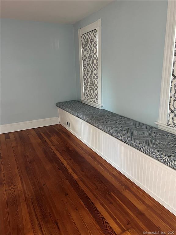interior space with baseboards and dark wood-style flooring