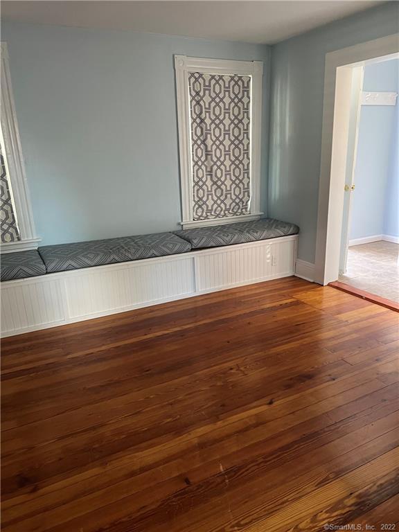 spare room featuring baseboards and hardwood / wood-style floors