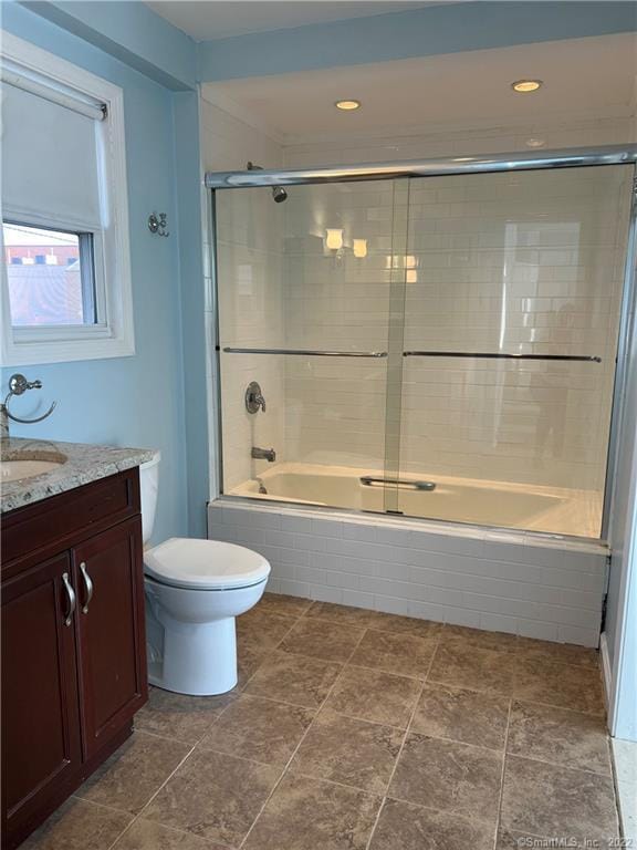 bathroom featuring toilet, vanity, and tiled shower / bath