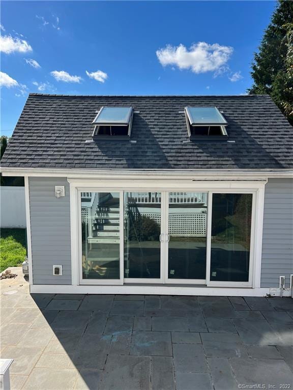 back of house featuring a shingled roof and a patio