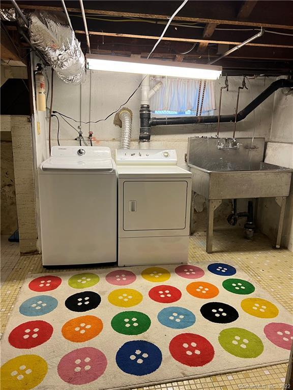 laundry room featuring washing machine and clothes dryer, laundry area, and a sink