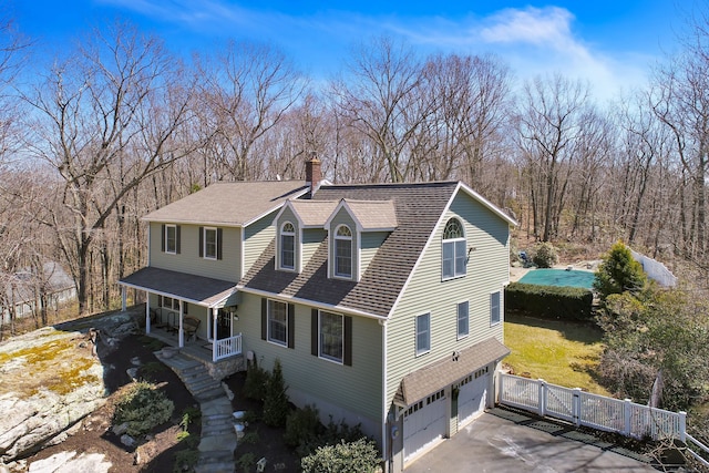 view of front of property featuring stairway, a chimney, driveway, a porch, and a garage