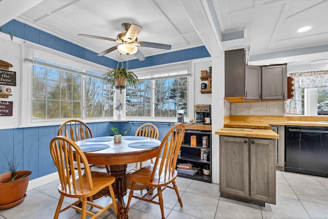 dining space with light tile patterned floors, a ceiling fan, and crown molding