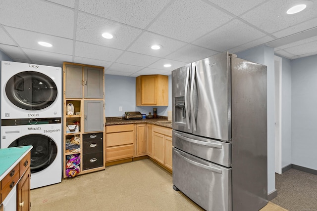 kitchen with light floors, recessed lighting, stainless steel refrigerator with ice dispenser, and stacked washer / drying machine