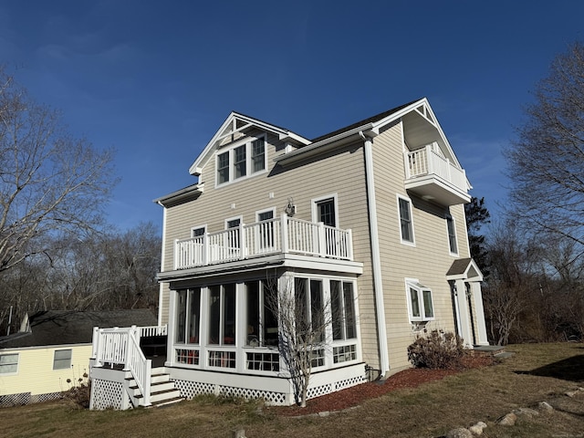 back of house featuring a sunroom and a balcony