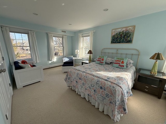 carpeted bedroom with a baseboard radiator, visible vents, baseboards, and recessed lighting