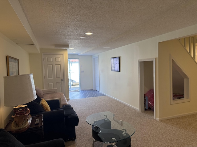 carpeted living area featuring a textured ceiling, stairs, and baseboards