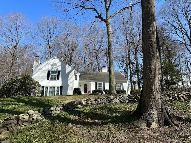 view of front of home featuring a front lawn and a chimney