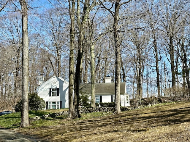 view of front facade featuring a chimney and a front yard