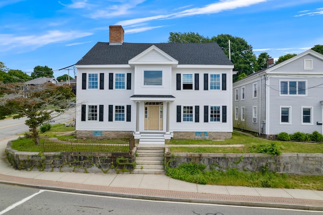 view of front of house featuring roof with shingles and a chimney