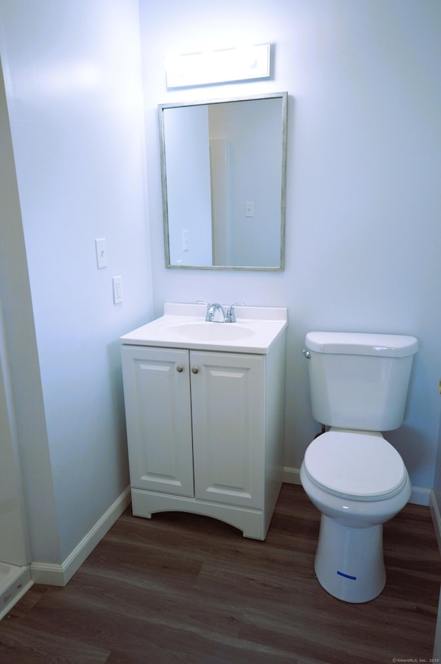 bathroom featuring vanity, toilet, and baseboards