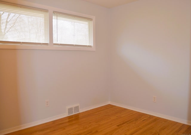 unfurnished room with baseboards, visible vents, and light wood-style floors