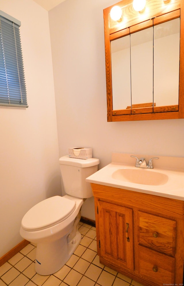 half bath featuring baseboards, vanity, toilet, and tile patterned floors