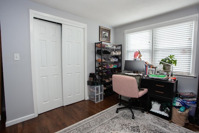 home office with a textured ceiling, baseboards, and wood finished floors