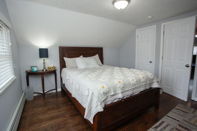 bedroom with a textured ceiling, a baseboard heating unit, vaulted ceiling, and wood finished floors