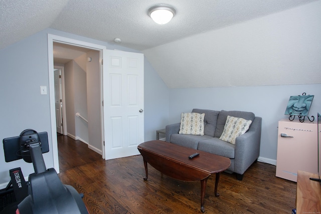 living room with lofted ceiling, a textured ceiling, baseboards, and wood finished floors