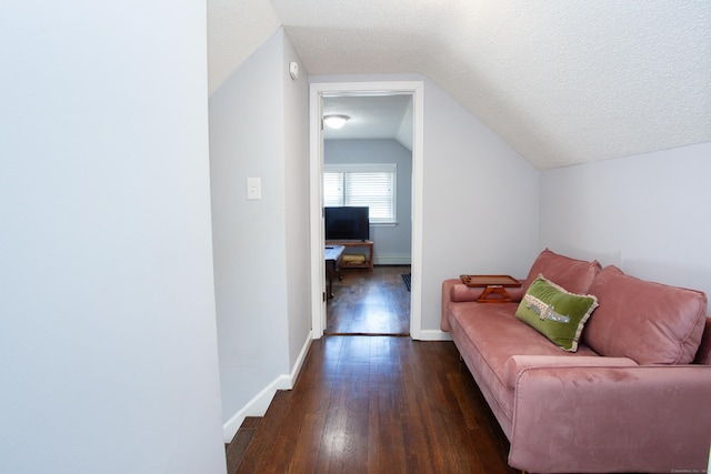 living room with a textured ceiling, a baseboard heating unit, dark wood-type flooring, baseboards, and vaulted ceiling