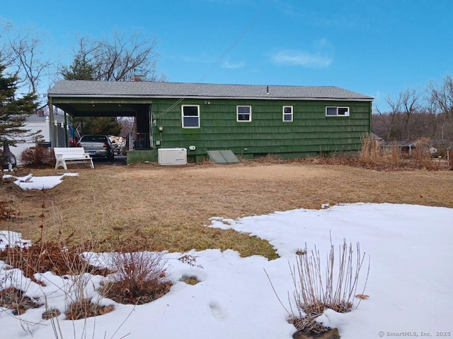 exterior space featuring a shingled roof and a carport