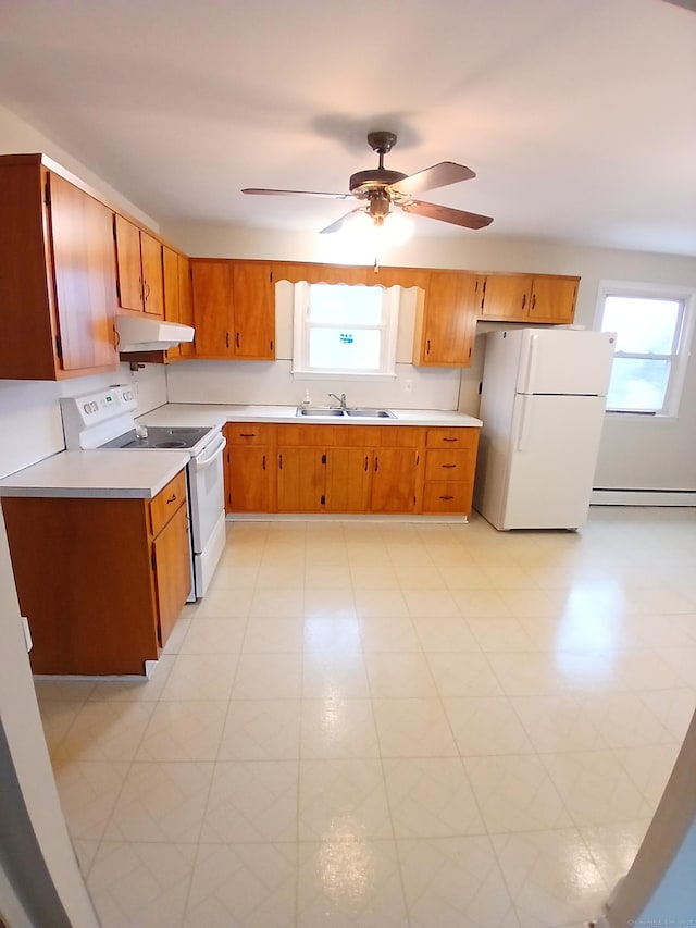 kitchen featuring a wealth of natural light, light countertops, a sink, white appliances, and under cabinet range hood