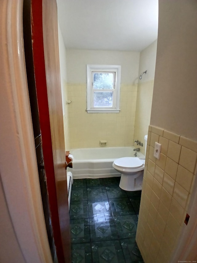 bathroom with toilet, shower / bath combination, tile patterned flooring, and tile walls