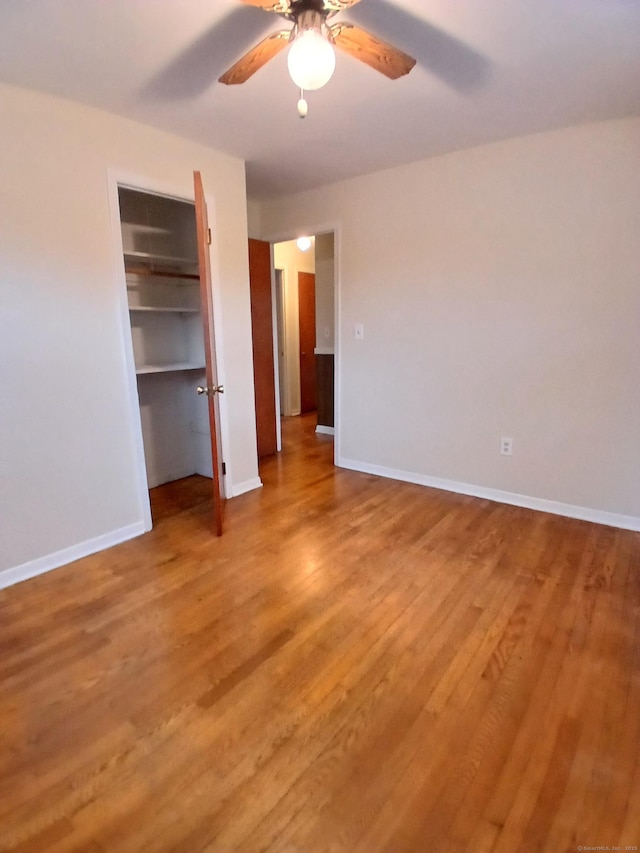 unfurnished bedroom with ceiling fan, light wood finished floors, a closet, and baseboards