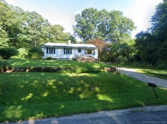 view of front of house featuring a chimney and a front lawn