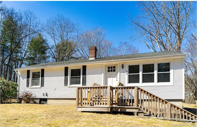 ranch-style house with a front lawn, a wooden deck, and a chimney